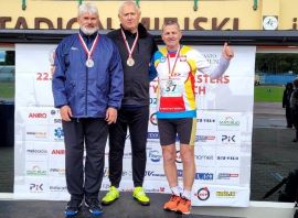 Trzech mężczyzn stoi na podium. Wszyscy mają medale 