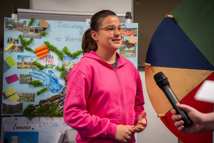 Dziewczynka w różowej bluzie podczas udzielania wywiadu 