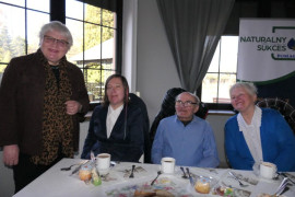 Trzy kobiety i mężczyzna. Jedna z kobiet stoi 