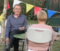 Dwie osoby siedzące przy stoliku na świeżym powietrzu 