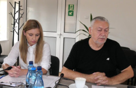 Kobieta i mężczyzna siedzą przy stole. Prowadzący spotkanie 