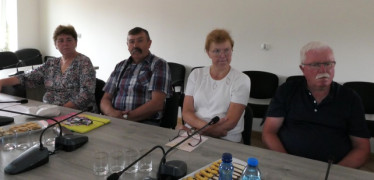 Osoby siedzą przy stole. Uczestnicy spotkania
