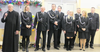 Grupa osób: strażacy i ksiądz 