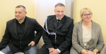 Dwaj mężczyźni i kobieta siedzą obok siebie