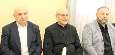 Dwaj mężczyźni i ksiądz siedzą obok siebie