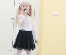 Dziewczynka podczas występu. Dziewczynka w ręku trzyma mikrofon 