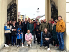 Grupa osób stojąca w bramie wejściowej na zamek w Uniejowie 