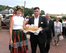Kobieta i mężczyzna. Mężczyzna trzyma dożynkowy bochen chleba 