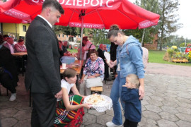 Starostowie dożynek częstują chlebem 