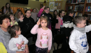 Grupa osób dorośli i dzieci. Widzowie, którzy oglądają teatralne przedstawienie 