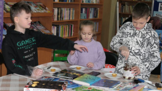 Dziewczynki i dwaj chłopcy podczas dekorowania babeczek