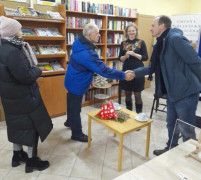 Grupa osób. Osoby znajdują się w bibliotece 
