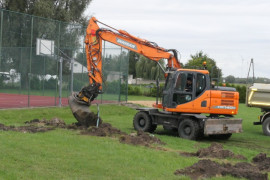 Koparka podczas prac na boisku sportowym 