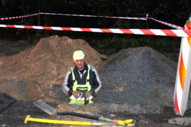 Głęboki wykop i mężczyzna przy wykonywaniu robót związanych z kanalizacją 