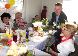 Mężczyzna wręcza kobietom doniczkowe kwiaty
