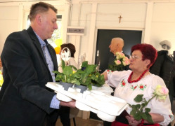 Kobieta odbiera od mężczyzny prymulkę (kwiatek w doniczce)