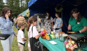 Grupa osób przy stoisku wystawienniczym 