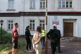 Grupa osób przed budynkiem 