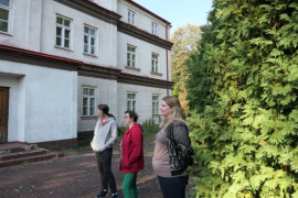Grupa osób stoi przed budynkiem 