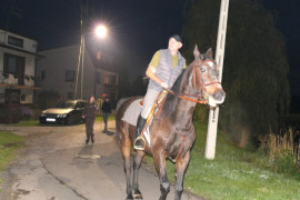 Mężczyzna jadący na koniu. Za nim idą panie uczestniczące w marszu Nordic Walking