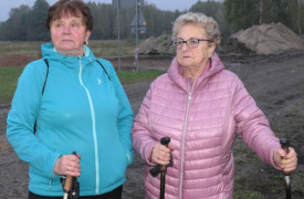 Dwie kobiety stojące obok siebie. Kobiety trzymają w dłoniach kijki Nordic Walking 