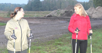 Dwie kobiety podczas rozgrzewki przed marszem Nordic Walking 