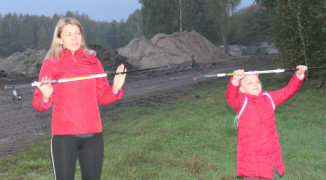 Kobieta i dziewczynka podczas rozgrzewki przed marszem Nordic Walking 