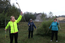 Trzy kobiety podczas rozgrzewki przed marszem Nordic Walking 