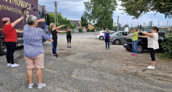 Grupa kobiet podczas rozgrzewki przed marszem Nordic Walking