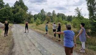 Grupa kobiet podczas rozgrzewki przed marszem Nordic Walking
