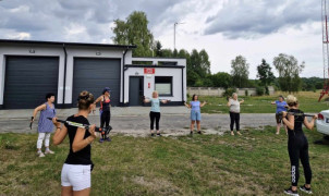 Grupa kobiet podczas rozgrzewki przed marszem Nordic Walking