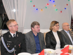 Spotkanie opłatkowe: kobieta i trzech mężczyzn siedzi za stołem