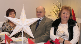 Spotkanie opłatkowe: dwie kobiety i mężczyzna siedzą przy stole 