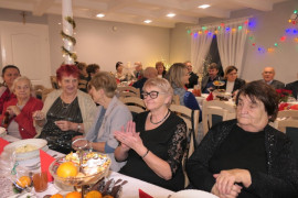 Spotkanie opłatkowe: osoby siedzą przy stołach