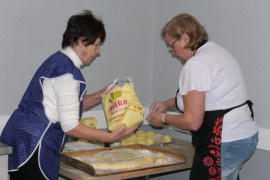 Dwie kobiety przygotowują ciasto na pączki