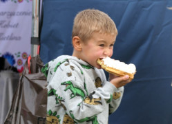 Chłopiec jedzący gofra z bitą śmietaną 
