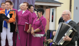 Kobiety śpiewają, mężczyzna gra na akordeonie 