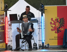 Mężczyzna siedzi na krześle i gra na akordeonie 