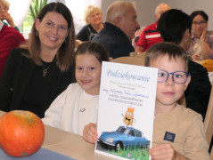 Kobieta i dwójka dzieci. Dzieci trzymają dyplom 