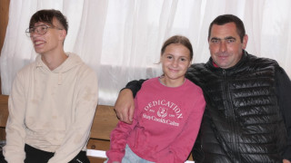 Mężczyzna, chłopiec i dziewczyna siedzą przy stole 