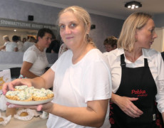 Dwie kobiety. Jedna z nich trzyma w ręku talerz z potrawą 