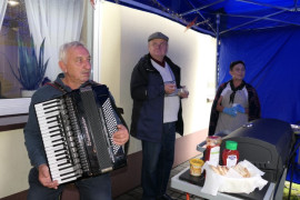 Kobieta i dwóch mężczyzn. Jeden z mężczyzn gra na akordeonie 