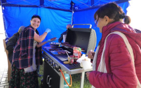 Dwie kobiety. Jedna z nich obsługuje grill 