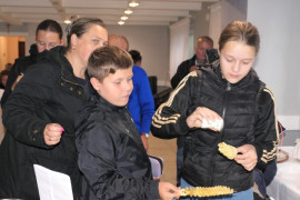 Grupa osób. Dziewczynka soli ziemniaki 
