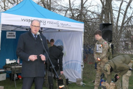 Mężczyzna stoi przy mikrofonie i przemawia 