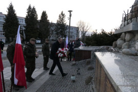 Moment składania kwiatów pod pomnikiem 