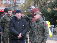 Grupa mężczyzn: żołnierze i cywile stoją obok siebie