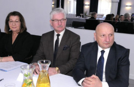 Kobieta i dwaj mężczyźni siedzą przy stole  