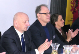 Dwaj mężczyźni i kobieta siedzą obok siebie przy stole 
