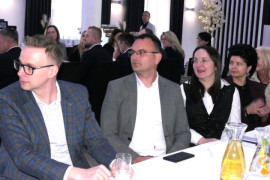 Dwie kobiety i dwaj mężczyźni siedzą obok siebie przy stole 